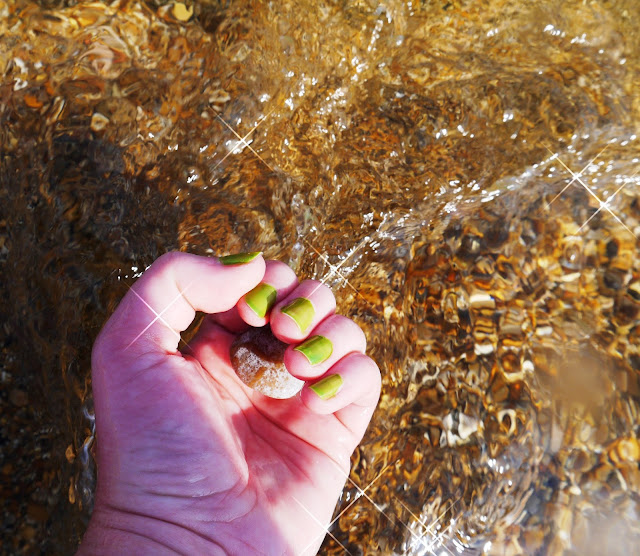 Hand Holding Pebble in the Sea