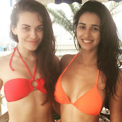 Disha Patani in orange halter bikini top with friend in red bandeau bikini top in a resort