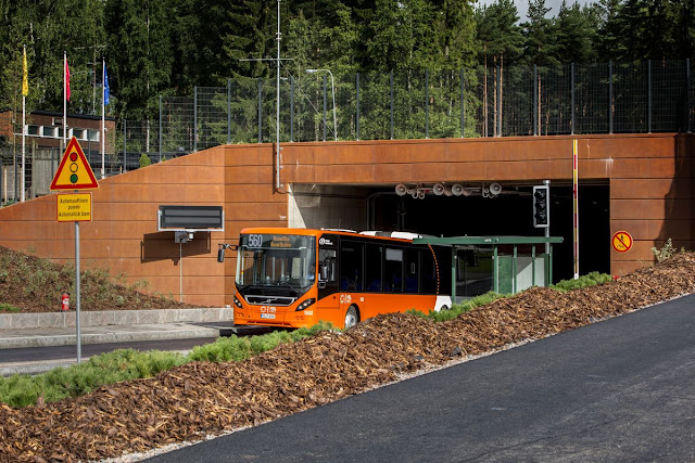 Runkolinjan 560 oranssi bussi tulossa Paloheinän tunnelista ulos.