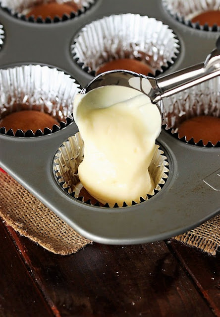Spooning Mini Cherry Cheesecake Batter into Muffin Cups Image