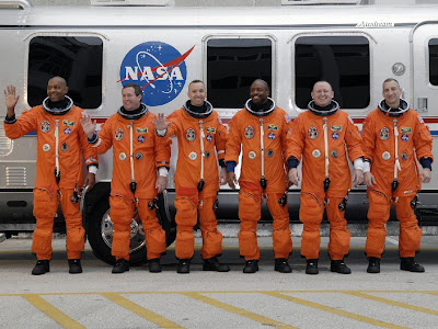 The STS-129 crew members line up beside the Astrovan