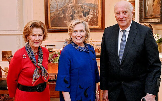 Queen Sonja wore a red midi dress. Gold brooch. Queen Sonja attended the concert with The Norwegian Girl's Choir