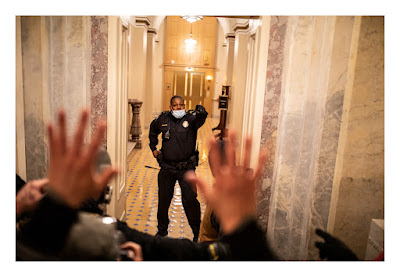 color photograph of Capitol police Office Eugen Goodman blocking January 6 rioters from Capitol