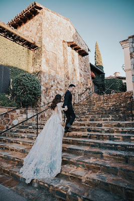 groom leading bride up bella collina staircase