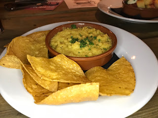 baked hummus and tortilla chips on a white plate