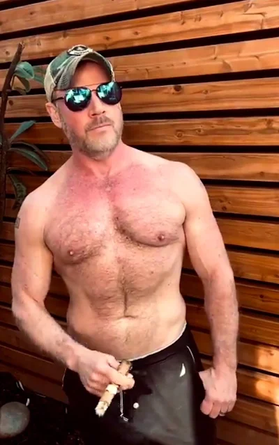 Hot dude wearing sunglasses shirtless smoking a cigar