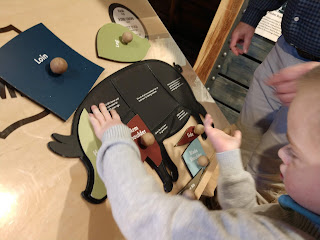 a boy in a gray sweater puts together a puzzle shaped like a pig at the Stockyards Ag Experience in Sioux Falls