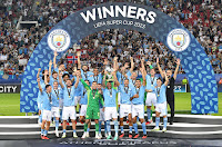 MANCHESTER CITY F. C. Temporada 2023-24. Los jugadores del Manchester City celebran su primer título de la Supercopa de Europa. MANCHESTER CITY F. C. 1 🆚 SEVILLA F. C. 1 En los penaltis: MANCHESTER CITY FC 5 🆚 SEVILLA FC 4 Miércoles 16/08/2023, 21:00 horas. 48ª edición de la Supercopa de Europa. El Pireo, Atenas, Grecia, estadio Giorgios Karaiskakis: 29.500 espectadores. GOLES: ⚽0-1: 25’, Youssef En-Nesyri. ⚽1-1: 62’, Cole Palmer. PENALTIS: ⚽1-0: Erling Haaland, gol. ⚽1-1: Lucas Ocampos, gol. ⚽2-1: Julián Álvarez, gol. ⚽2-2: Rafa Mir, gol. ⚽3-2: Mateo Kovačić, gol. ⚽3-3: Ivan Rakitić, gol. ⚽4-3: Jack Grealish, gol. ⚽4-4: Gonzalo Montiel, gol. ⚽5-4: Kyle Walker, gol. ❌5-4: Nemanja Gudelj, se estrella en el larguero.