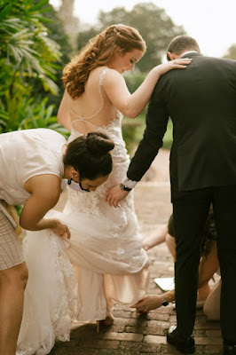 at last weddings coordinator fixing dress