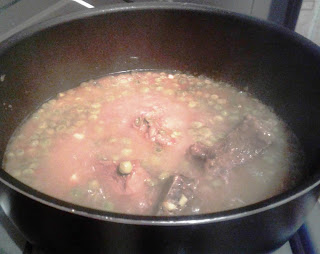 Tagine with peas and artichokes simmering on low heat