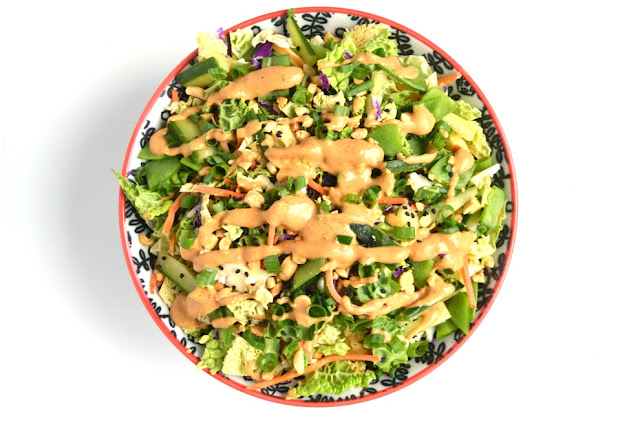 Spicy Peanut Asian Slaw is loaded with crisp and delicious vegetables that are topped with a creamy spicy peanut dressing, chopped peanuts, green onions and sesame seeds! www.nutritionistreviews.com