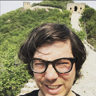Greig Roselli poses in front of a tower at the Simatai portion of the Great Wall of China