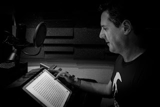 A black and white photo of narrator Matt Addis in the recording studio.