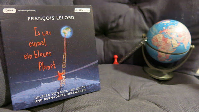 Hörbuch von Francois Lelord neben nachgestelltem CD-Cover mit einer Spielfigur, Leiter und Globus
