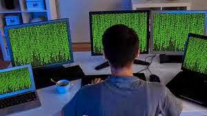 Man in Front of Several Computers at Work is an IT Professional