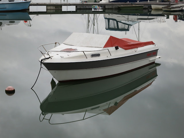 Moored boat with still-water reflection