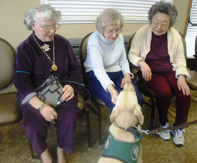 Reyna visiting with three ladies and one of them is pettin her head.