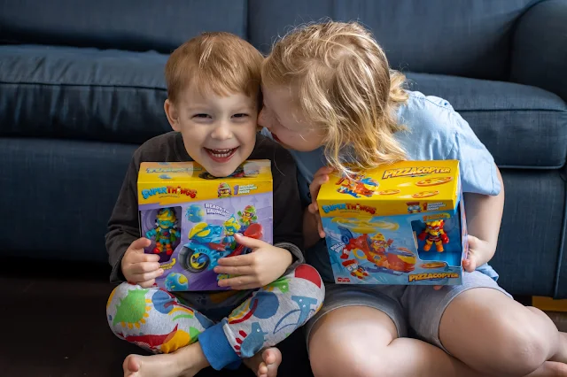 Two excited children holding Superthings boxes