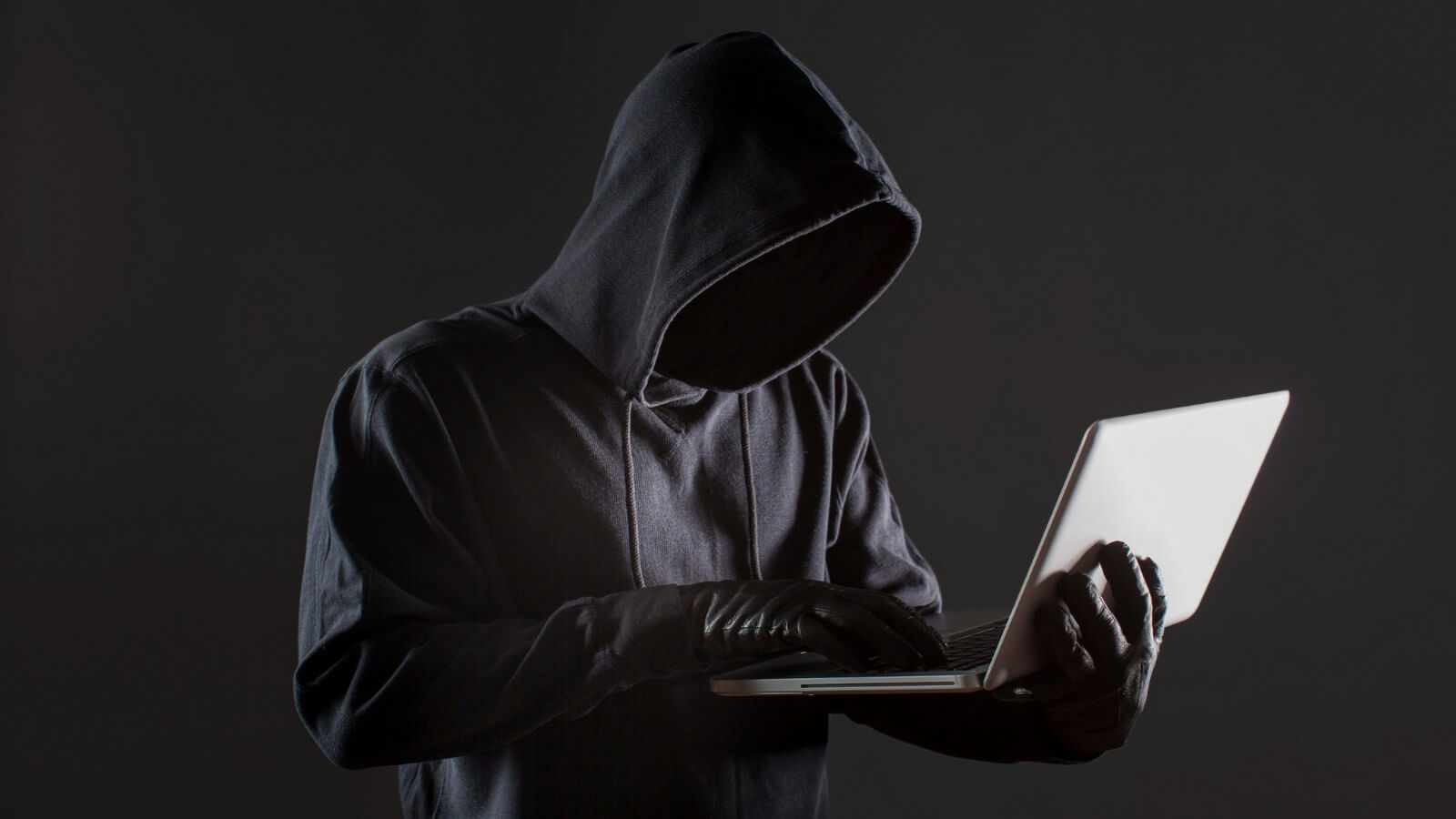 Free photo side view of male hacker with gloves and laptop