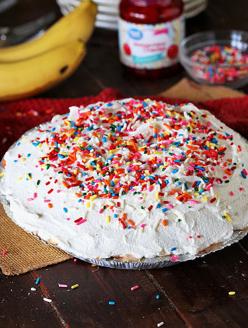 Frozen 7-Layer Banana Split Pie Topped with Whipped Cream and Rainbow Sprinkles Image