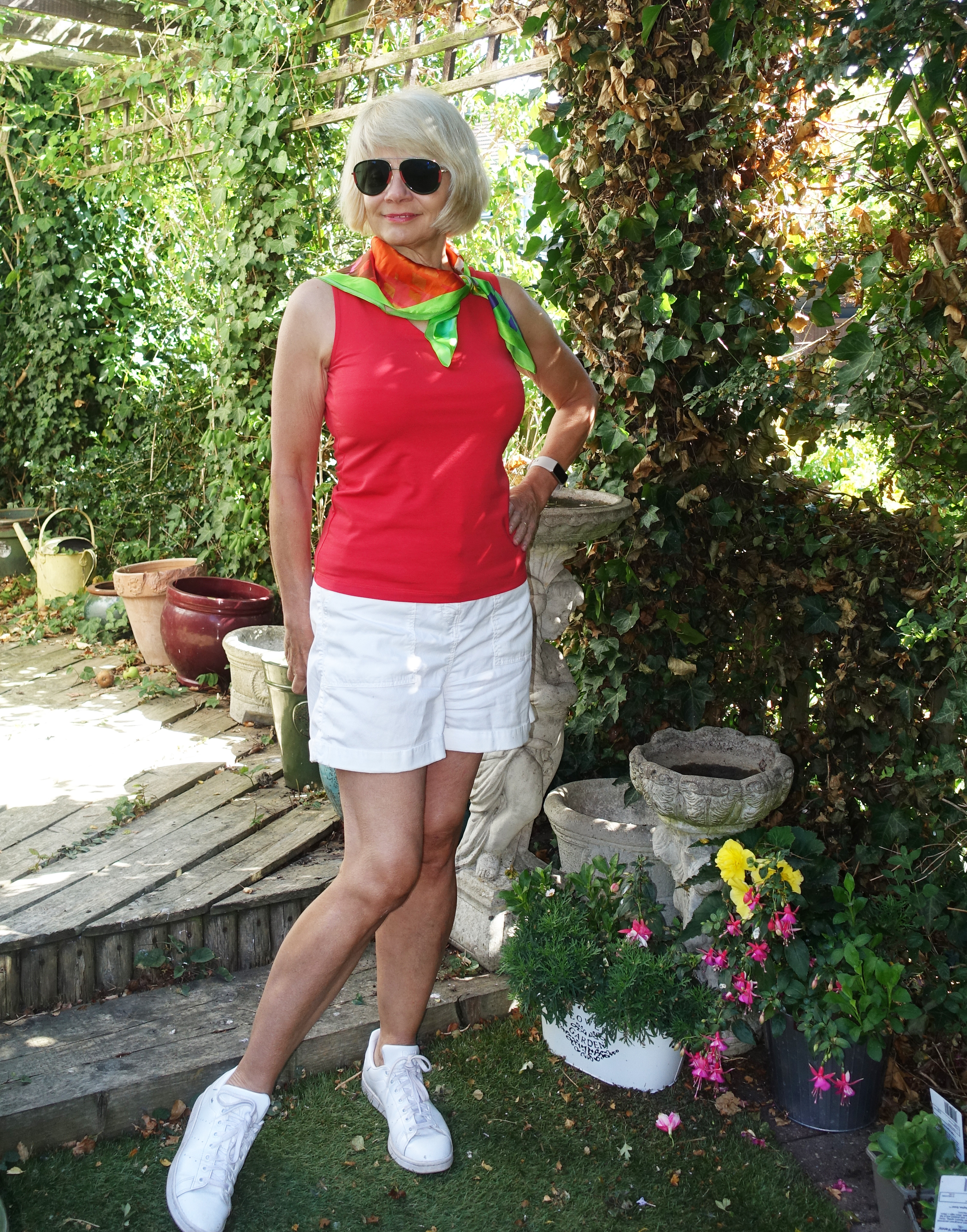 Women of any age can wear shorts of any length, says Gail Hanlon from Is This Mutton. Ignore all those click bait online posts saying older women shouldn't go near them!  Wearing white shorts Marks and Spencer and poppy red sleeveless V neck from Kettlewell. Spring scarf from My Season Jewellery.