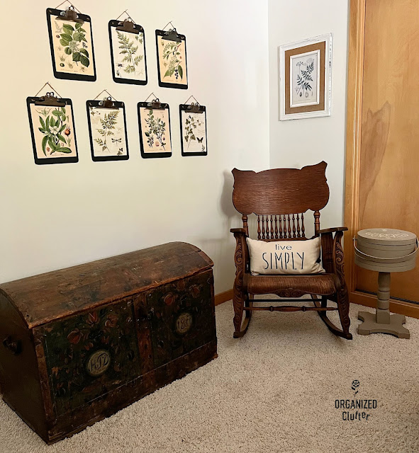Photo of a vintage Norwegian trunk, clipboards with botanical prints, and a vintage rocker.