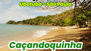 Playa de aguas calmas, flanqueada por una península rocosa, algunos árboles hacen sombra sobre la arena