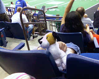 This child is staring directly up into his stuffed puppy's hinder