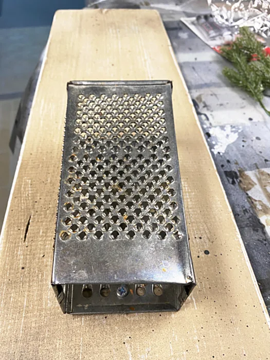 cheese grater screwed to board