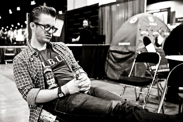 A guy sitting in a chair sleeping after puking onto the floor at the Great American Beer Festival in Denver.