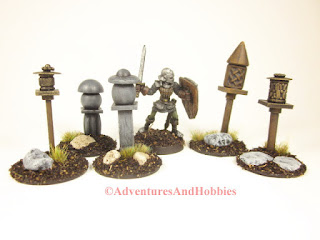 A miniature fantasy knight wanders through a group of 25-28mm scale shrines.