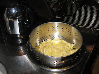 Grated potatoes draining in a colander