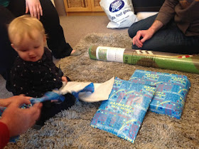 baby sat on floor with presents