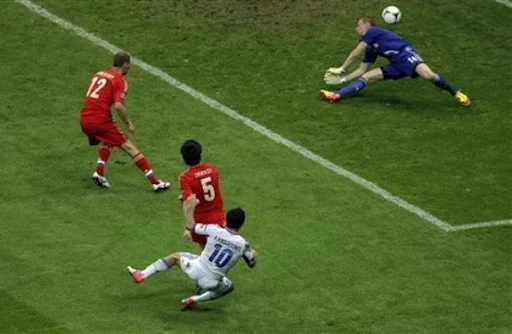 Greece player Giorgos Karagounis scores past Russia goalkeeper Vyacheslav Malafeev