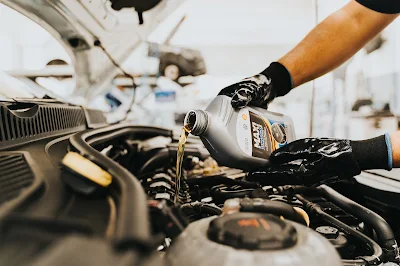 Mechanic changing engine oil under hood
