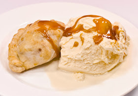 Baked apple empanada with vanilla ice cream and caramel