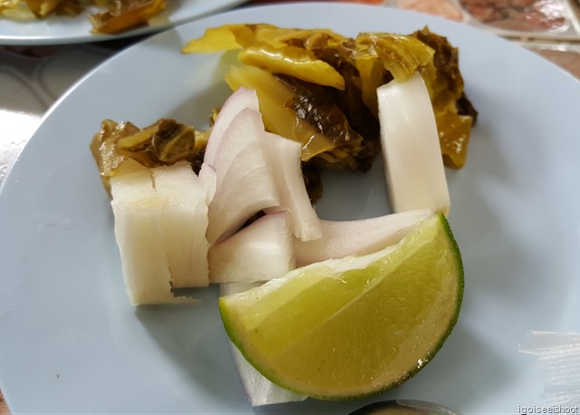 A slice of lime, chopped onions and pickled vegetables to add as toppings.