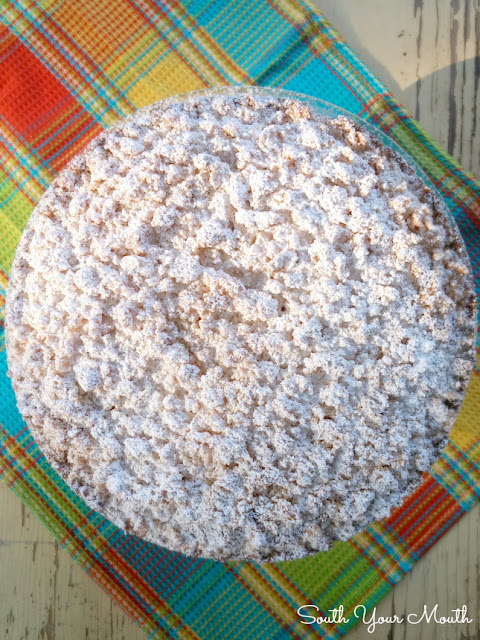 Lemon Crumble Cream Cake with a crumb topping dusted with powdered sugar, tender cake and lemon cream filling.