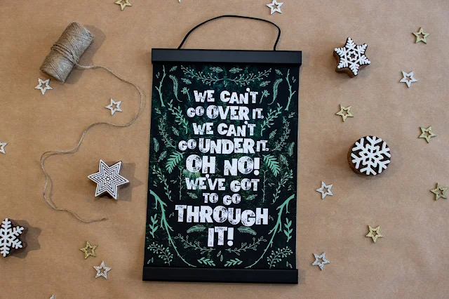 A print saying "we can't go over it, we can't go under it, Oh No! We've got to go through it!" in a magnetic hanging frame