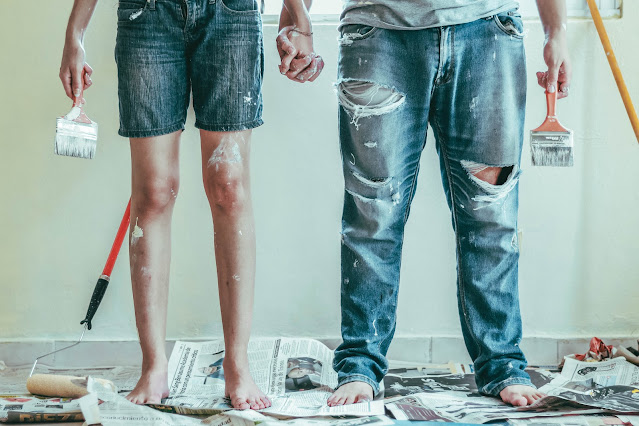 Two people dressed to paint house with painting equipment in hands and around:Photo by Roselyn Tirado on Unsplash