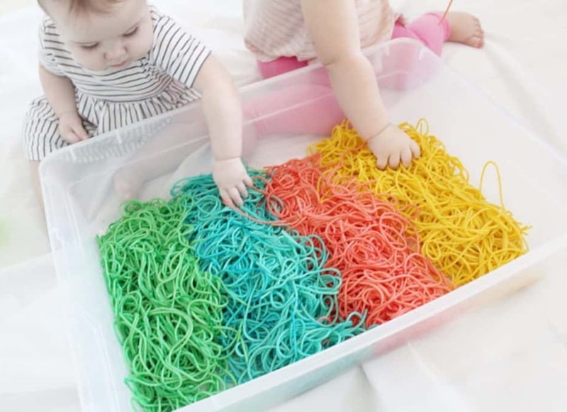 rainbow spaghetti sensory bin for babies.