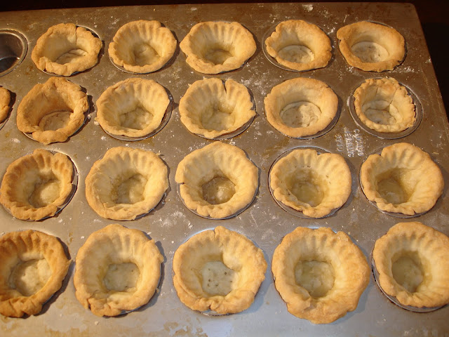 PORCIONES: 42 Conchitas. MINI CONCHITAS INGREDIENTES PARA LA MASA DE LAS CONCHITAS  450 g de harina cernida ½ cucharadita de sal 225 g de mantequilla fría 2/3 taza de agua bien fría 1 bandeja de muffins de 24 orificios. ( 3 cm de hondo x 5 cm de diámetro )  PREPARACIÓN En un recipiente redondo, poner la harina y la sal. Con un procesador de comida cortar la mantequilla hasta que la harina quede como azúcar granulada gruesa. Si no tiene procesador usar las yemas de los dedos y tratar de mezclar en forma rápida para no darle tiempo a la mantequilla de que se caliente. Agregar de a poquito el agua fría, lo suficiente para poder juntar la harina y poder formar una bola con ello. Dividir la bola en cuatro más peque ñas y poner en el refrigerador. Después de unos 30 minutos sacar una bola del refrigerador y hacer bolitas pequeñas de 25 gramos cada una. Espolvorear la mesa con un poquito de harina. Con un rodillo, estirar cada bolita, hasta que estas tenga aproximadamente un diámetro de 9 cm. Repetir el mismo procedimiento con el resto de la masa que está en el refrigerador. En la bandeja de hornear muffins, poner un poquito de spray de vegetal si es que no es de teflón. Acomodar las masitas estiradas, en los orificios de la bandeja, apretando suavemente hacia los costados y el fondo de la bandeja, dejando un pequeño borde sobresaliente hacia los costados, aproximadamente 3 mm. Con un escarbadientes pinchar el fondo de la masa unas cuantas veces. Precalentar el horno a 220° C - 430°F. Cocinar las conchitas unos 20 minutos, hasta que estas queden doradas. Sacar de la bandeja una vez que se han enfriado un poco, pero no completamente para que no se peguen.