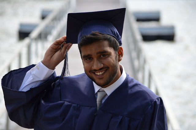 A young graduate touching his cap