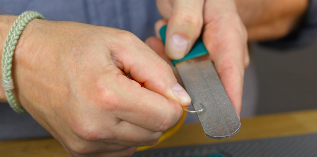 Brian Flechsig from Mad River Outfitters sharpening a hook on a Dr. Slick Hook Sharpener