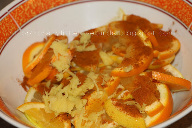 Sliced oranges, ginger, and cinnamon mixture inside of bowl