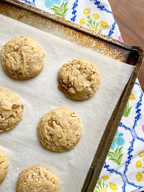 Salted Butter Pecan Cookies on parchment paper on a baking sheet.