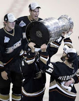 Anaheim Ducks' captain Scott Niedermeyer hands over the Stanley Cup to his brother Rob Niedermeyer (R) after Game 5 of the 2007 NHL Stanley Cup Finals hockey series in Anaheim, California, June 6, 2007. REUTERS/Danny Moloshok (UNITED STATES) 