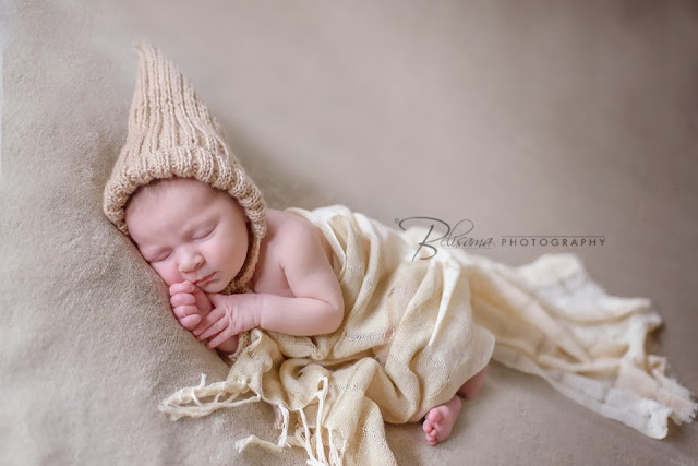 newborn baby girl wearing pixie hat sleeping