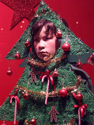 A sad dummy dressed like a Christmas tree