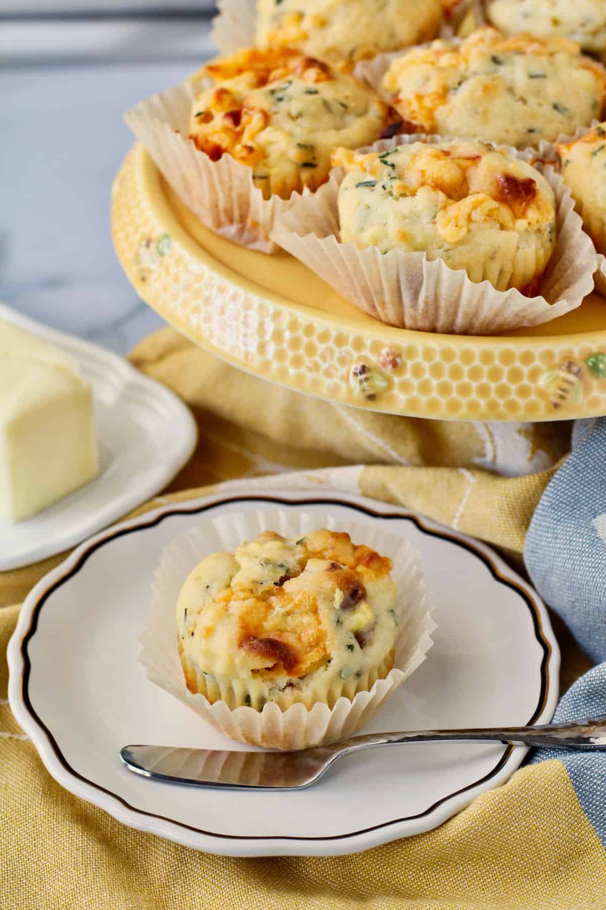 Cheddar, Bacon, and Potato Muffins with a butter knife on a plate.